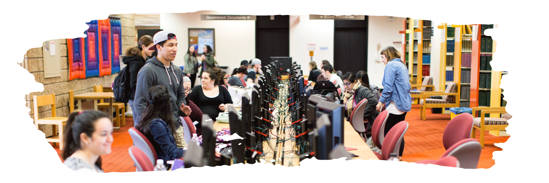 Students gathered at a bank of computers in a library