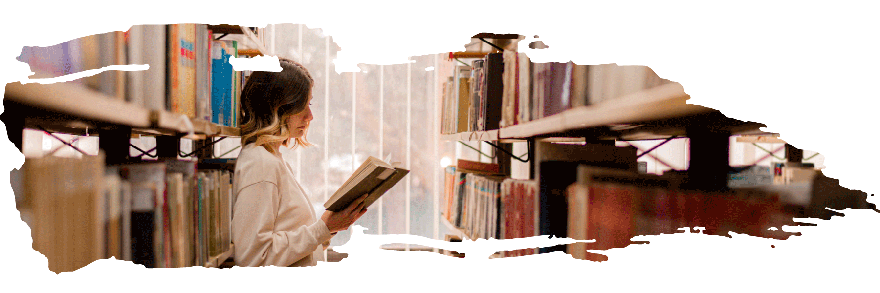 Young woman reading a book in the library stacks