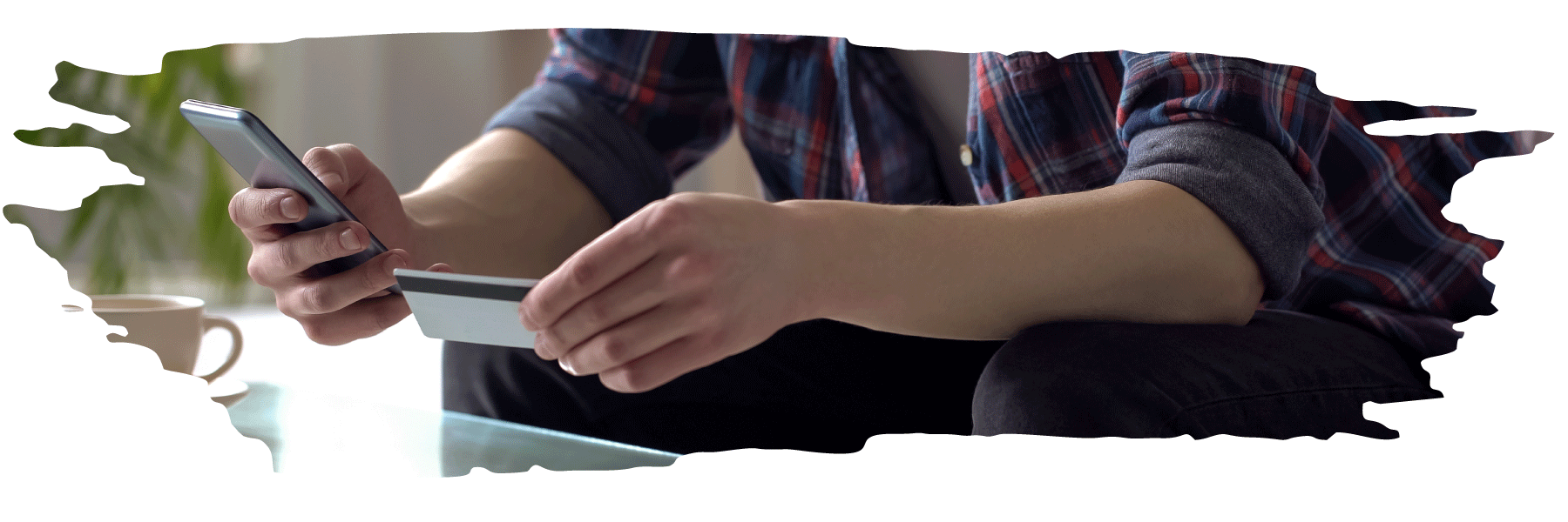 close-up of student holding a credit card in one hand and entering the credit card number into his smartphone with his other hand