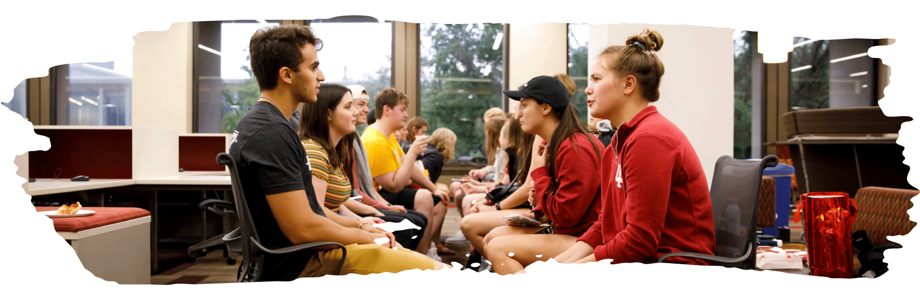 Several pairs of students lined up facing each other talking