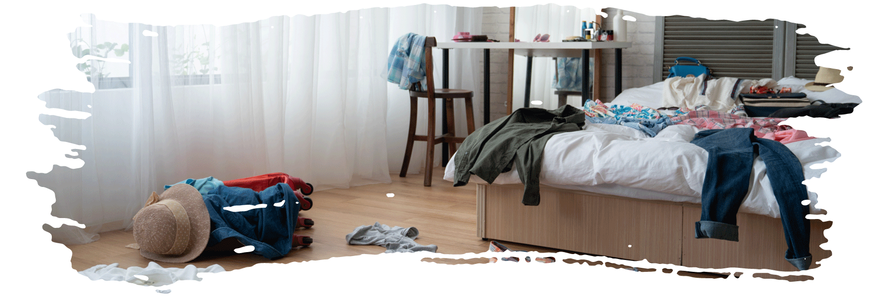 A bedroom with clothing lying around on the bed and floor