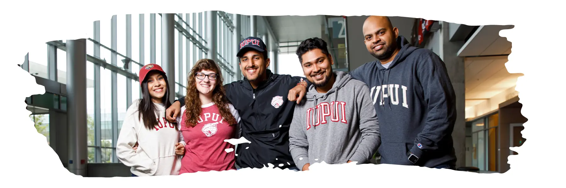 Five students wearing IUPUI gear posing for a photo in the IU Indianapolis Campus Center