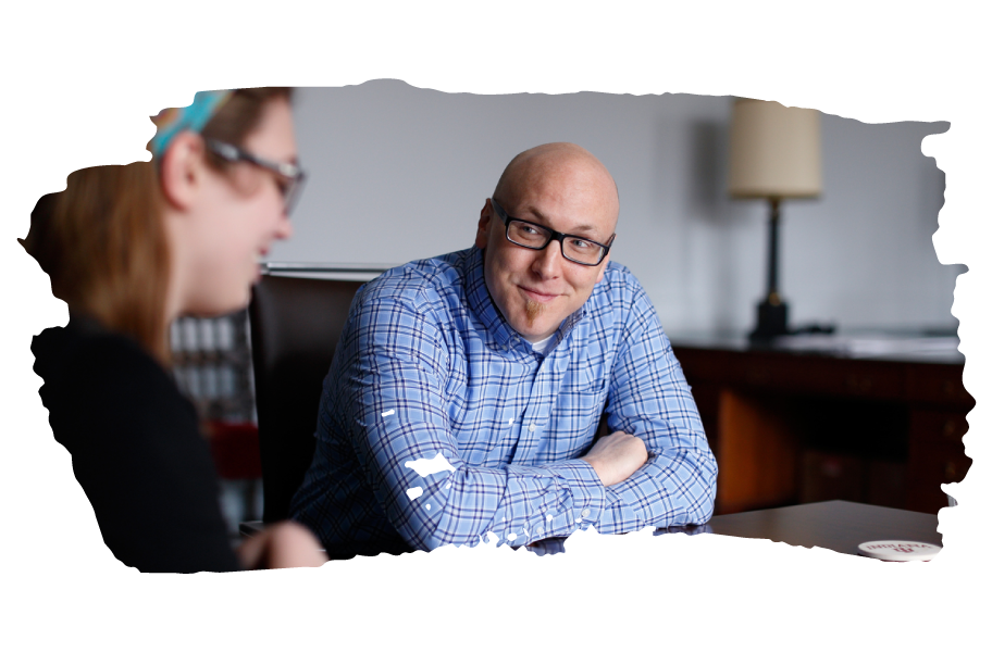 An academic advisor sitting at a table with a student