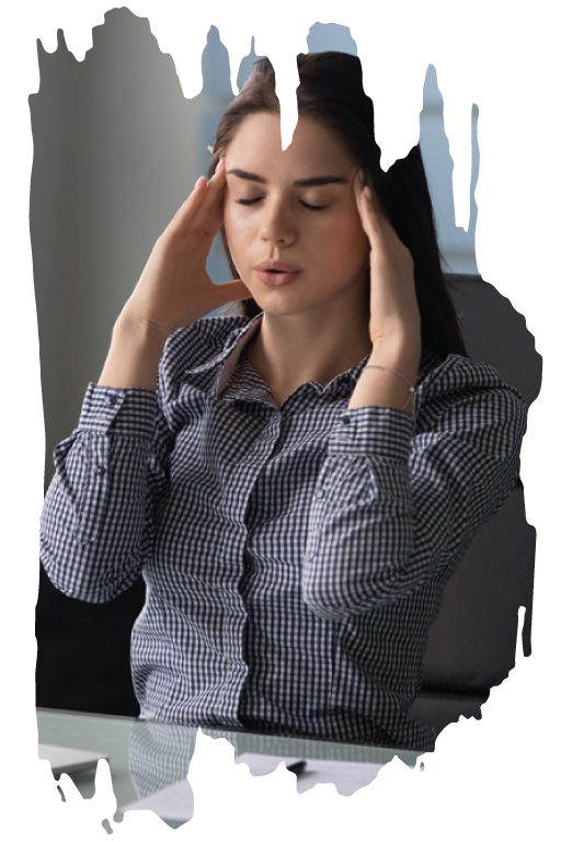 A woman sitting with eyes closed and holding her fingers to her temples 